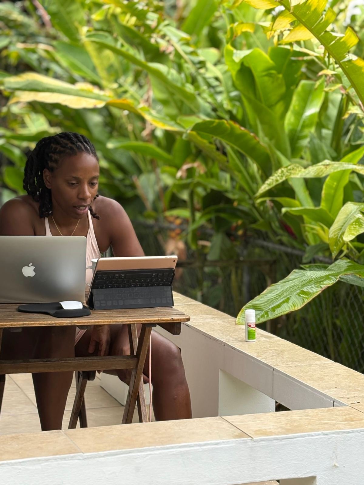 Massinda Zinga writing at a laptop in a garden