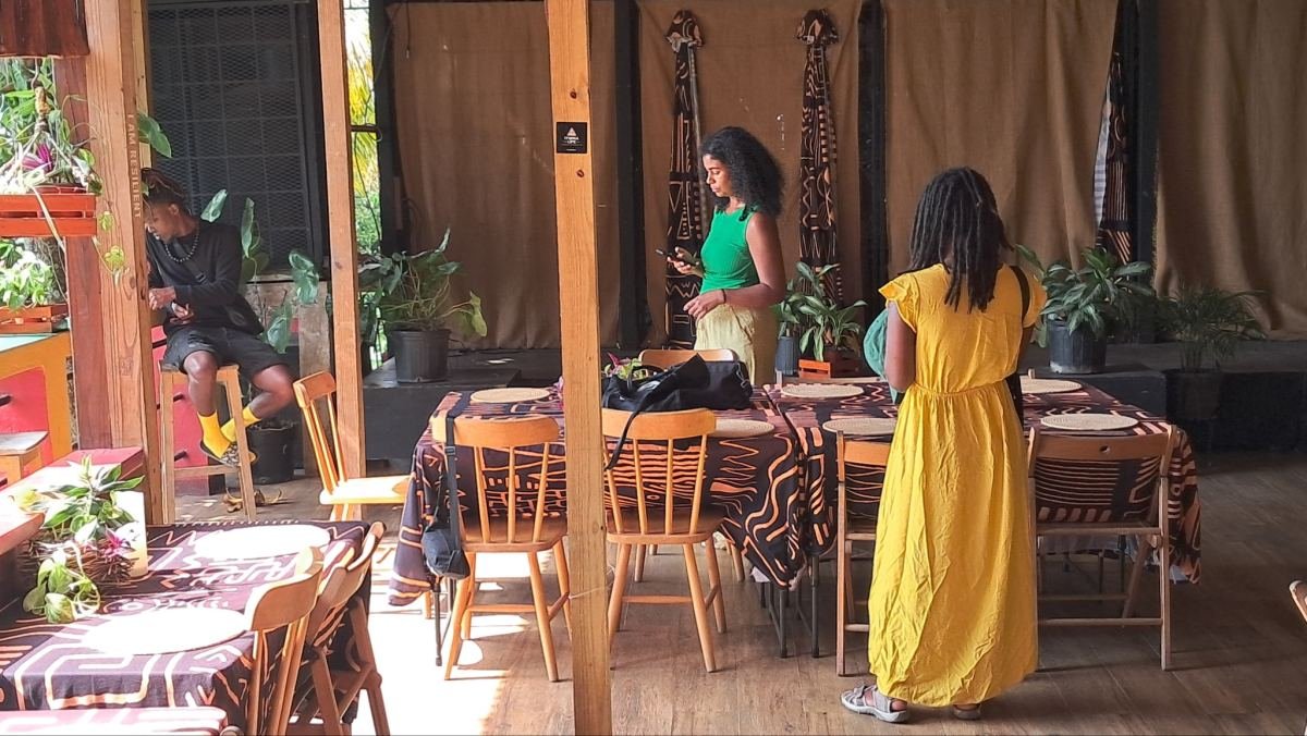 Women arriving in a wooden dining room laid with long tables