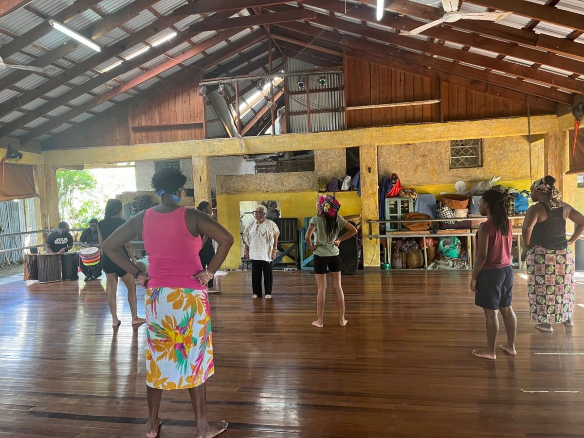 A group warming up in a large wooden dance studio