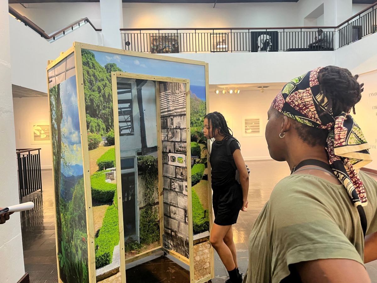 Visitors looking at a painted landscape installation in a gallery