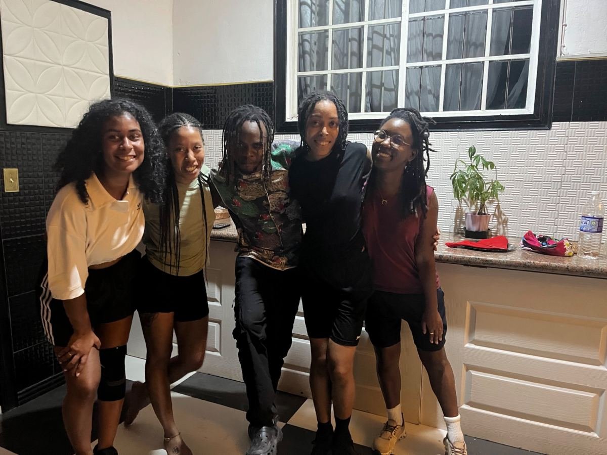 A group of women smiling together in a kitchen