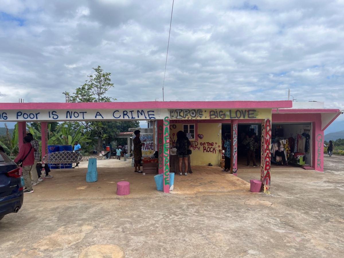 A pink roadside building painted with messages about self love
