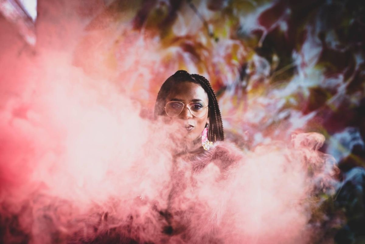 Massinda Zinga surrounded by clouds of pink smoke